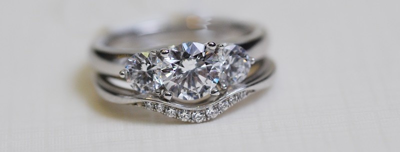 Curve shaped wedding ring with trilogy engagement ring